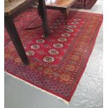 Red ground Bokhara style rug with central gul devices. (B.P. 24% incl.