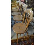 Set of four early 20th Century elm and beech spindle back kitchen chairs on circular moulded seats.