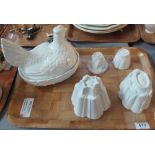 Four ceramic jelly moulds, varying designs including shelly,