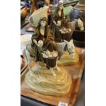 A pair of continental pottery figures on horseback with cylinder spill vase on a naturalistic base,