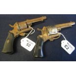 Two similar pin fire open frame revolvers with folding triggers.