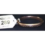 A 9ct gold hinged engraved bangle. (B.P. 24% incl.