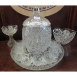 Heavy cut glass lidded punch bowl on circular stand with drinking glasses,
