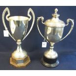 Two silver plated two-handled trophy cups, one with cover, both on socle bases. (B.P. 24% incl.