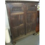 17th century style carved oak two-door blind paneled cupboard with the interior revealing