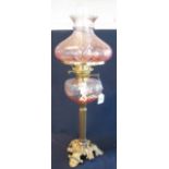Brass double burner oil lamp with glass reservoir and brass pedestal base with a coloured glass