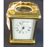 French brass carriage clock with full depth Roman enamel face, swing handle and key. 12 cm high. (B.