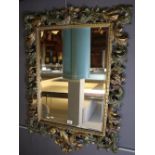 Modern pierced gilt wood mirror with overall scroll work framing and bevelled plate.