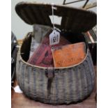 Wicker fishing creel containing various vintage tackle items, fly box, fly wallet, angling book,