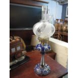 Early 20th century brass single burner oil lamp with overlay glass reservoir, pedestal and base,