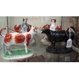 Two pottery cow creamers,