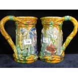 Two Victorian majolica single handled jugs overall with relief figural and leaf decoration,