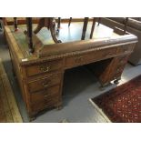 Early 20th Century walnut desk with leather inset top and three drawers to each pedestal on ball