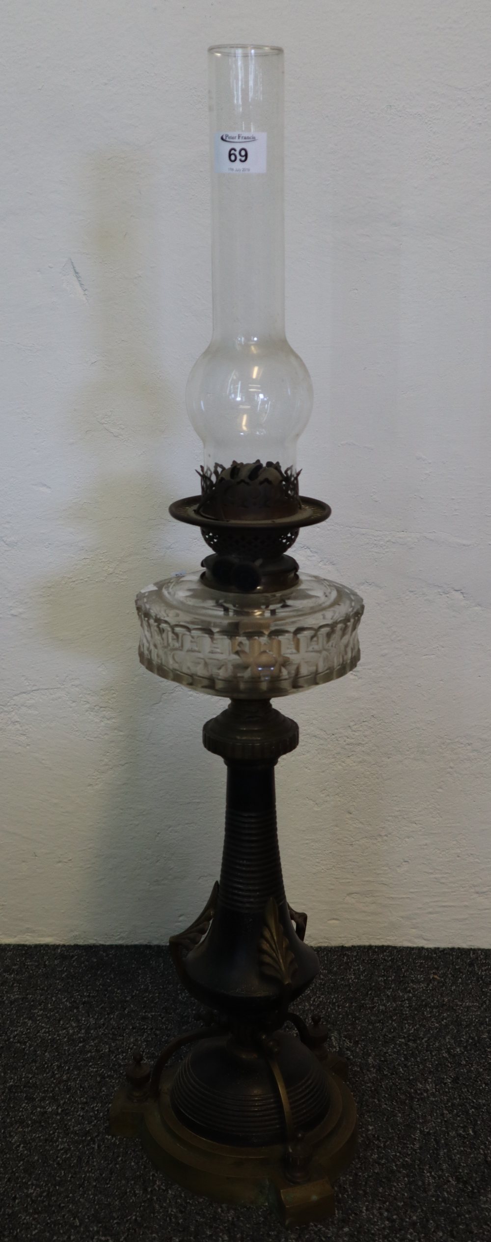 Late 19th Century brass double burner oil lamp with clear cut glass reservoir on a yellow metal and