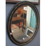 Oval mirror with ebonised and gilded frame. 50 x 39cm approx. (B.P. 24% incl.