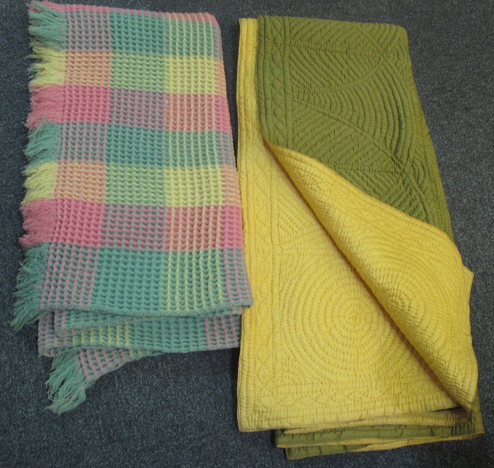 A vintage double size quilt with green on one side and yellow on the other,