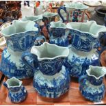 Two trays of reproduction blue and white oriental design pouch shaped graduated dresser jugs,