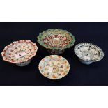 Group of four small porcelain and pottery polychrome decorated pedestal circular dishes or bowls,