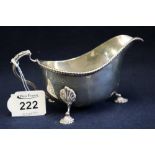 Silver gadroon edge sauce boat in Georgian style with loop handle and three shell moulded feet.