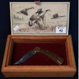 Buck brass and stainless steel lock knife with bird decoration to the blade,