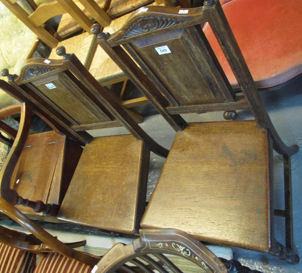 Pair of oak Edwardian hall chairs with rectangular fielded panels to the back on turned legs.