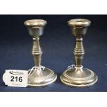 Pair of silver dwarf candlesticks with loaded bases and Birmingham hallmarks. 10.5cm high approx.