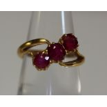 A yellow metal three stone ruby ring. Approx weight 4.2g. (B.P. 24% incl.