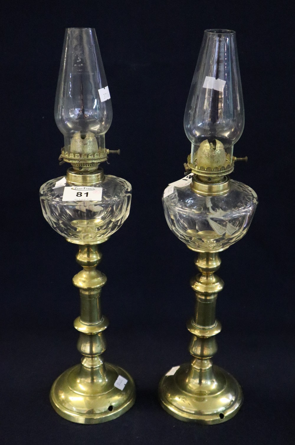 Pair of small single burner brass oil lamps with glass reserviors and brass bases, clear chimneys.