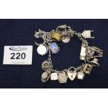 Charm bracelet with various silver and other charms, chain and heart shaped padlock. (B.P. 24% incl.