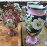 A pair of porcelain vases painted with white roses and foliage on a pink pedestal base,