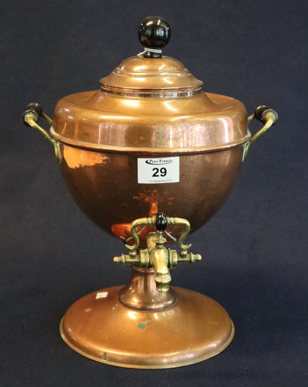 19th Century copper urn with two handles and brass tap on pedestal base. 32cm high approx. (B.P.