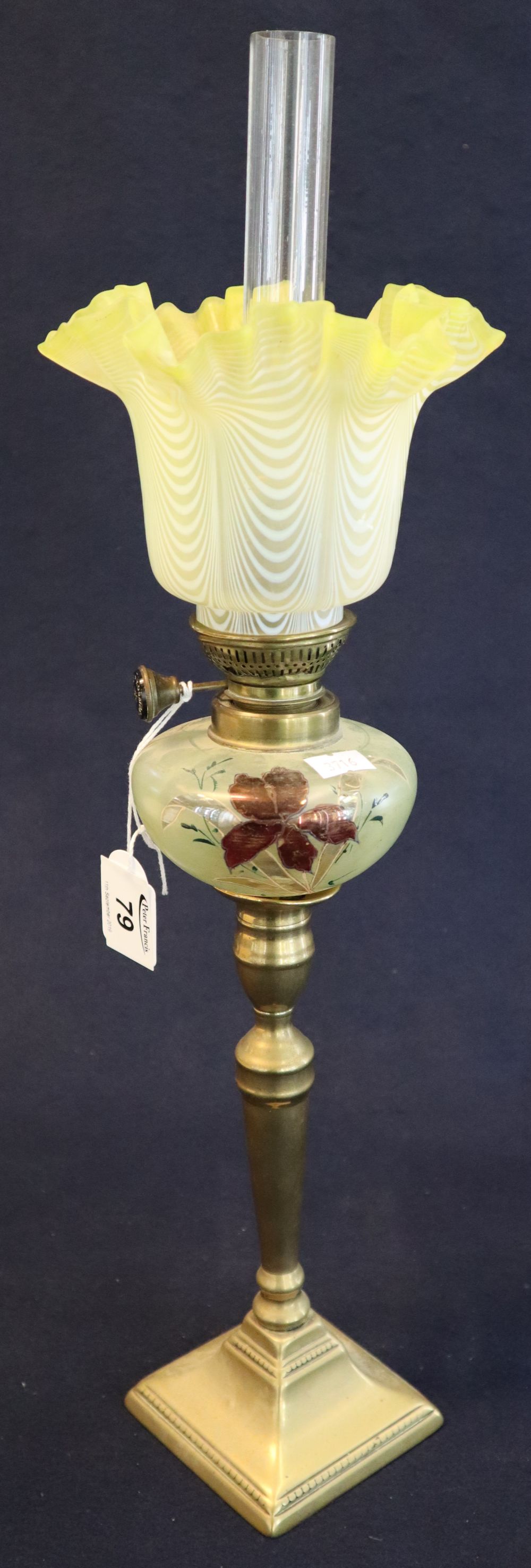 Small brass oil lamp with painted glass reservoir on brass vase shaped pedestal with square base,