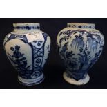 Two tin glazed blue and white Delft baluster shaped vases each with reserved floral panels.