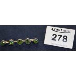 A five stone peridot bar brooch. (B.P. 24% incl.