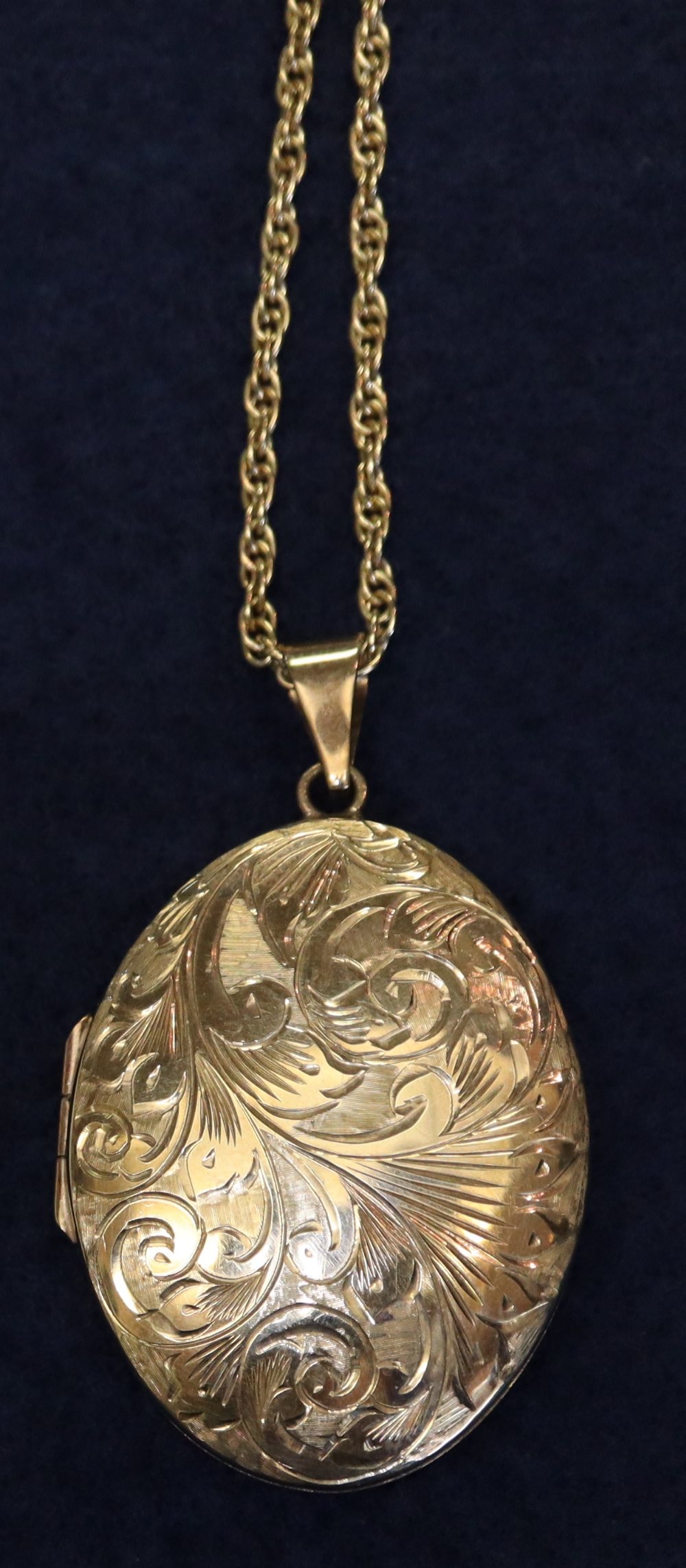 An oval engraved 9ct gold locket on 9ct gold chain. 18g in total approx. (B.P. 24% incl.