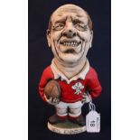 A John Hughes pottery Grogg of MP Neil Kinnock in a Welsh rugby shirt holding a ball.