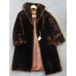 A dark brown vintage knee length beaver lamb/mouton fur coat with 'Exclusive Royal Castor best