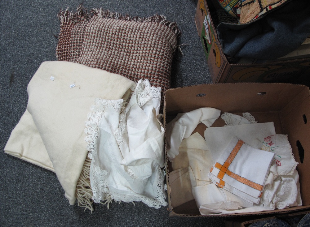 A box of vintage textiles to include; a cream fringed woollen blanket,