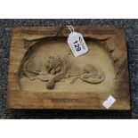 Small carved wooden panel depicting a sleeping lion with Latin inscription, dated 1792.