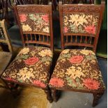 Pair of Arts and Crafts carved oak dining chairs, the backs and seats with foliate upholstery.