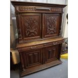 17th Century style heavily carved oak two stage blind panelled cupboard on stand. (B.P. 24% incl.