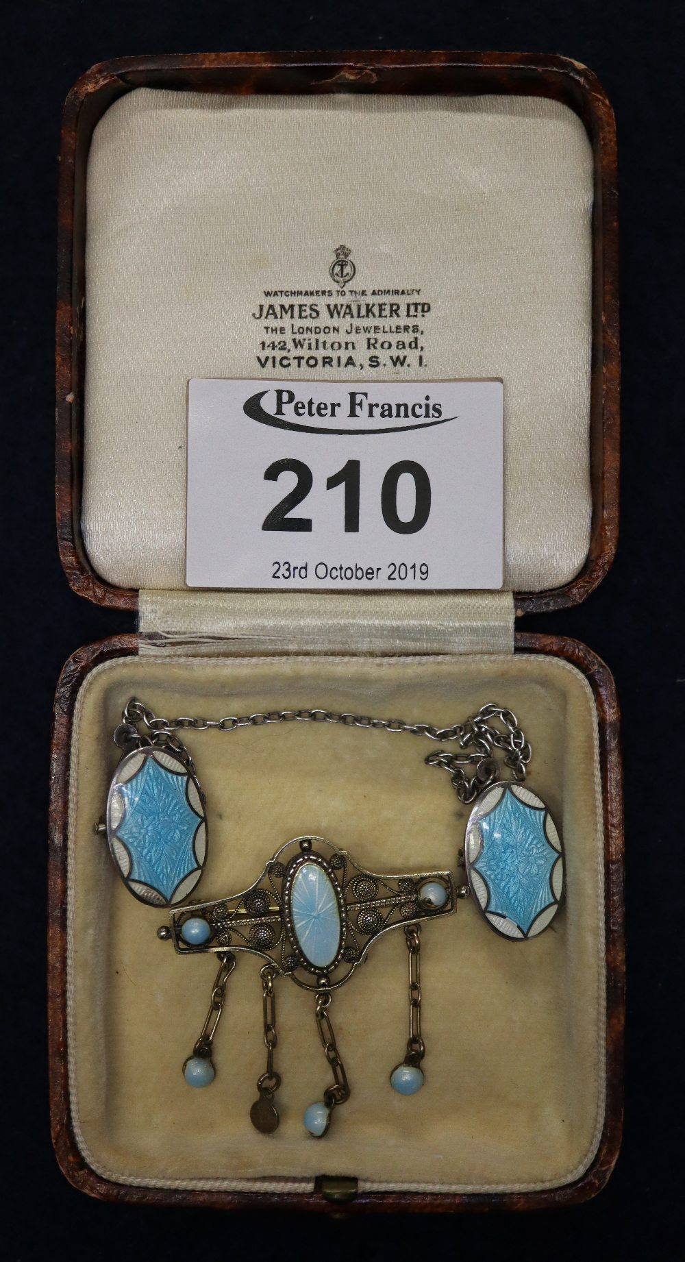 A sterling silver cloak clasp decorated with blue and white guilloche enamel and an 800 silver