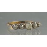 A VICTORIAN FIVE STONE DIAMOND RING. The old cut diamonds collet set in a yellow metal band.
