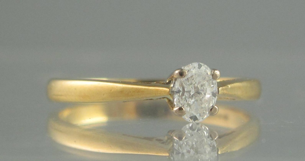 AN OVAL DIAMOND SOLITAIRE RING set in 18