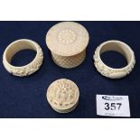 Two carved oriental ivory napkin rings, together with two carved screw top pill boxes. (B.P.