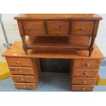 Modern pine kneehole desk with a bank of four drawers to each pedestal,