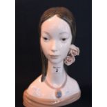 A Lladro Spanish porcelain bust of a young girl with flowing hair and roses with necklace. (B.P.