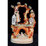 19th Century Staffordshire flat backed figure group on bridge with branches and river and swan