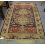 Middle Eastern design carpet on a beige and navy ground with central field of lozenges with foliate