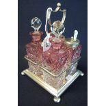Early 20th Century silver plated and cranberry glass four bottle cruet set on bun feet. (B.P.